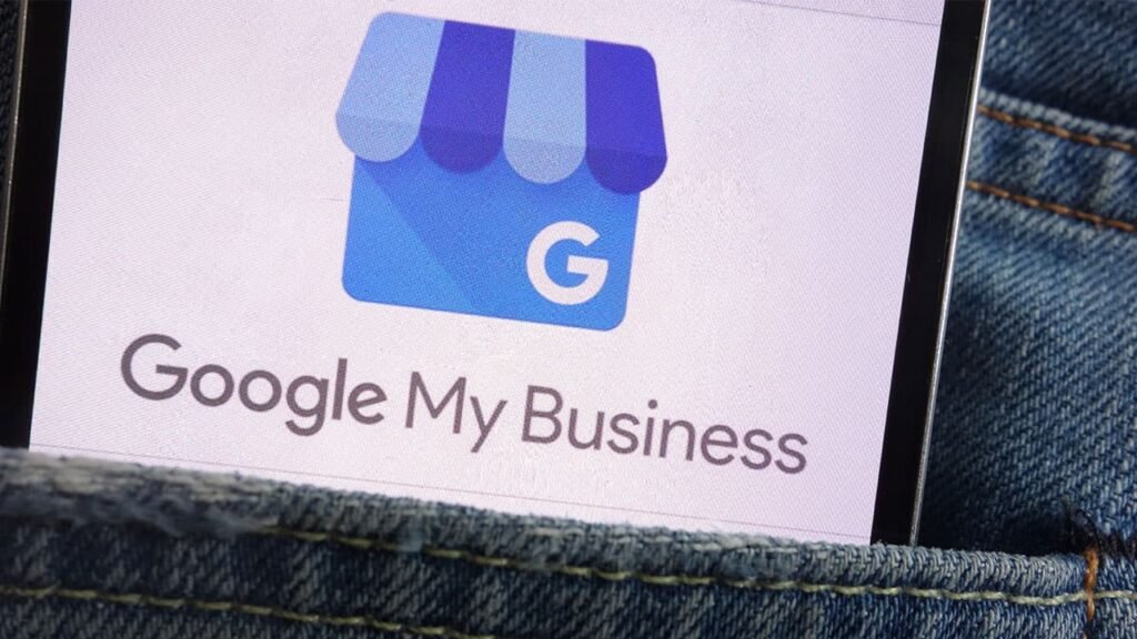 Google My Business logo displayed on a smartphone screen, partially tucked into a denim pocket, highlighting the use of the platform for managing local business listings.